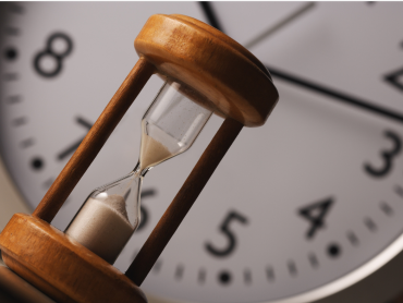 horloge avec en avant plan un sablier