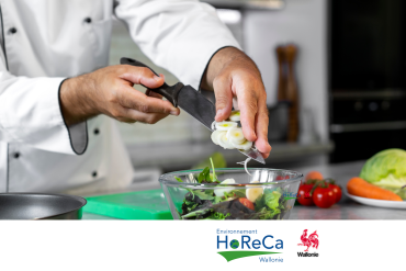 hef cuisinier coupant des légumes et les ajoutant dans un saladier dans une cuisine professionnelle, avec le logo Environnement HoReCa Wallonie.